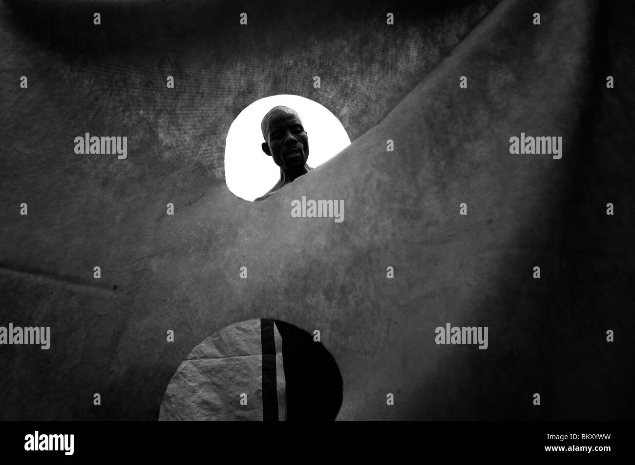 Un terremoto superstite visto trhough tenda realizzata di lamiera a una temporanea dimora di fortuna composto a Port au Prince dopo un terremoto di magnitudine 7.0 ha colpito Haiti il 12 gennaio 2010 Foto Stock