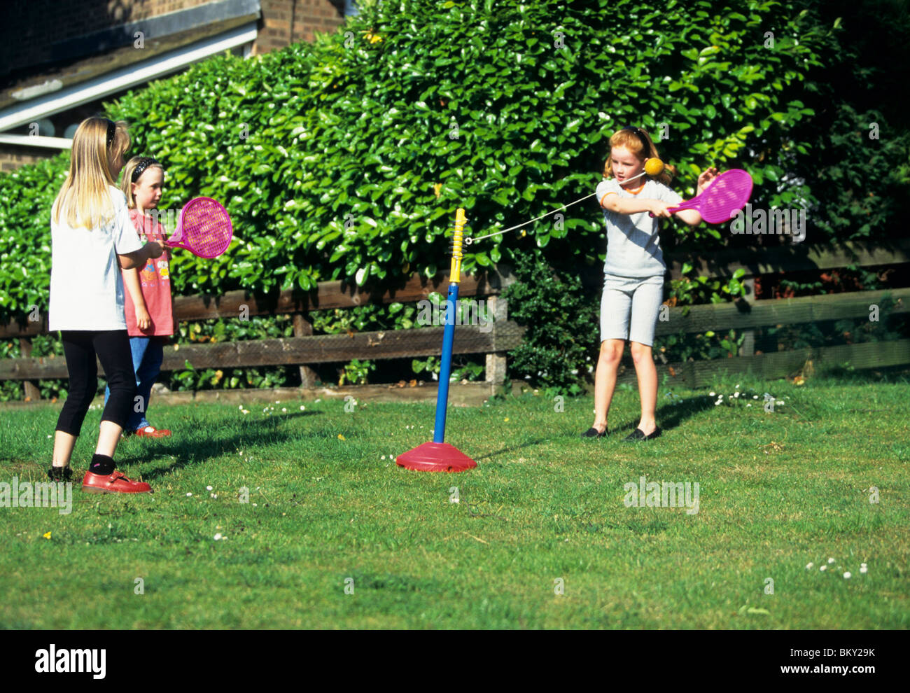 Tre giovani ragazze giocando un bat e il gioco con la palla in giardino Foto Stock