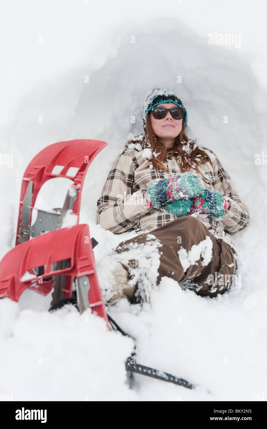 Giovane donna si appoggia sulla neve con le racchette da neve in Milcreek Canyon, Salt Lake City, Utah. Foto Stock