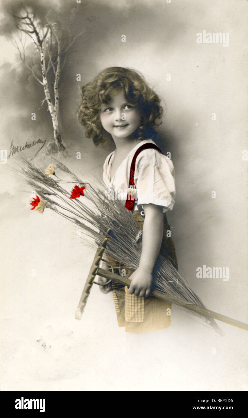 Fotografia di un giovane ragazzo che trasportano fiori e un rastrello (c.1912) Foto Stock