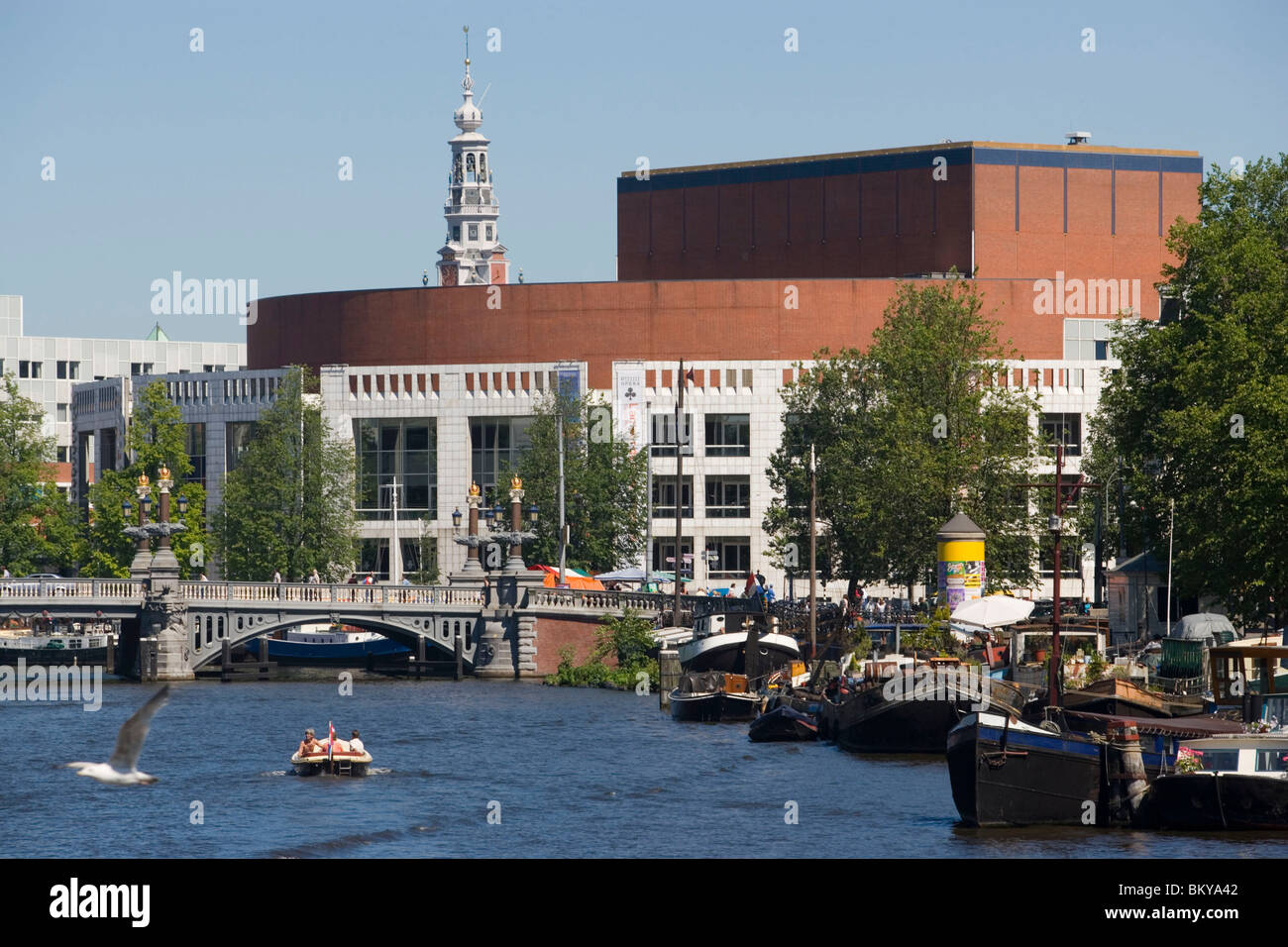 Barche, Amstel, Stopera Theatre, persone in barca sul fiume Amstel passando Stopera, il muziektheater di Amsterdam, Amsterdam, Olanda, Ne Foto Stock