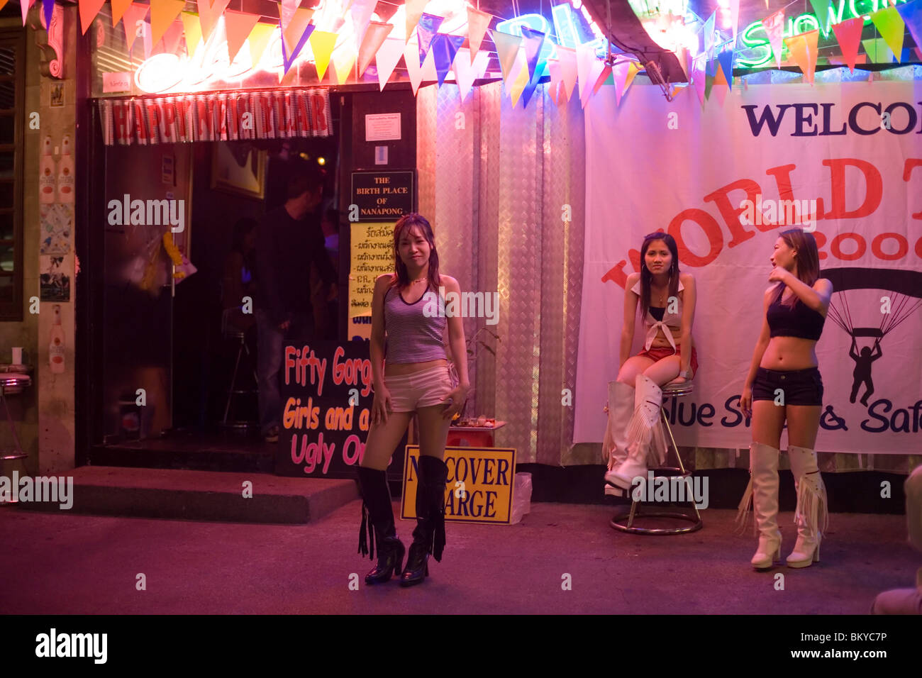 Tre go-go le ragazze nella parte anteriore di un nightclub, Patpong, la luce rossa e il quartiere dei divertimenti, Bang Rak distretto, Bangkok, Thailandia Foto Stock