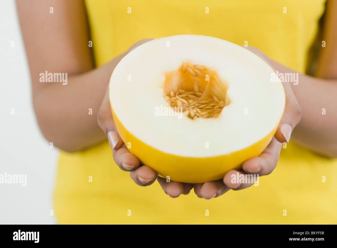 Donna che mantiene un metà del melone di Sun Foto Stock