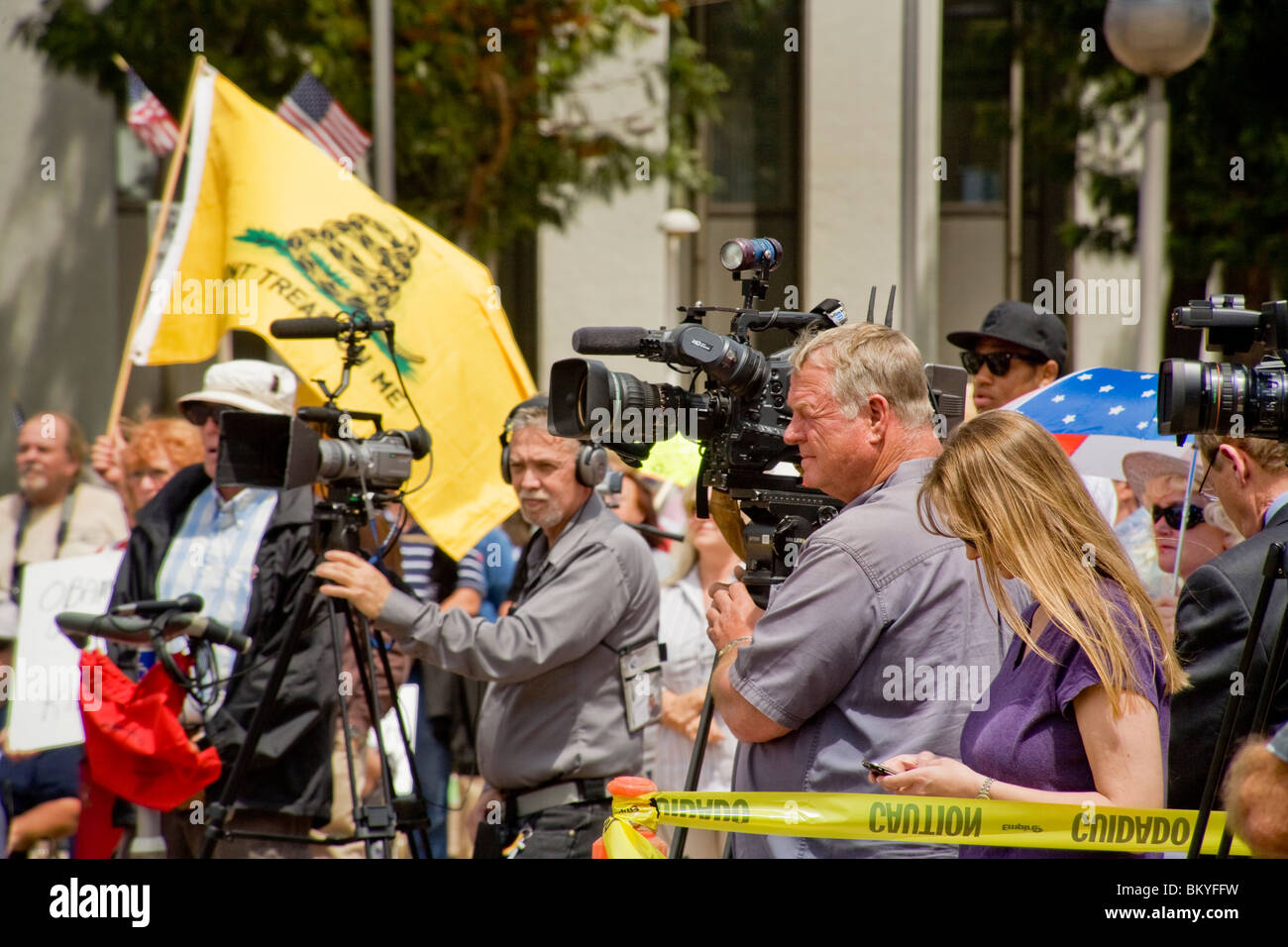 Notizie della televisione le troupe di coprire un 'Tea Party' rally su Aprile 15 (giorno d'imposta) in Santa Ana, California. Nota bandiera in background. Foto Stock