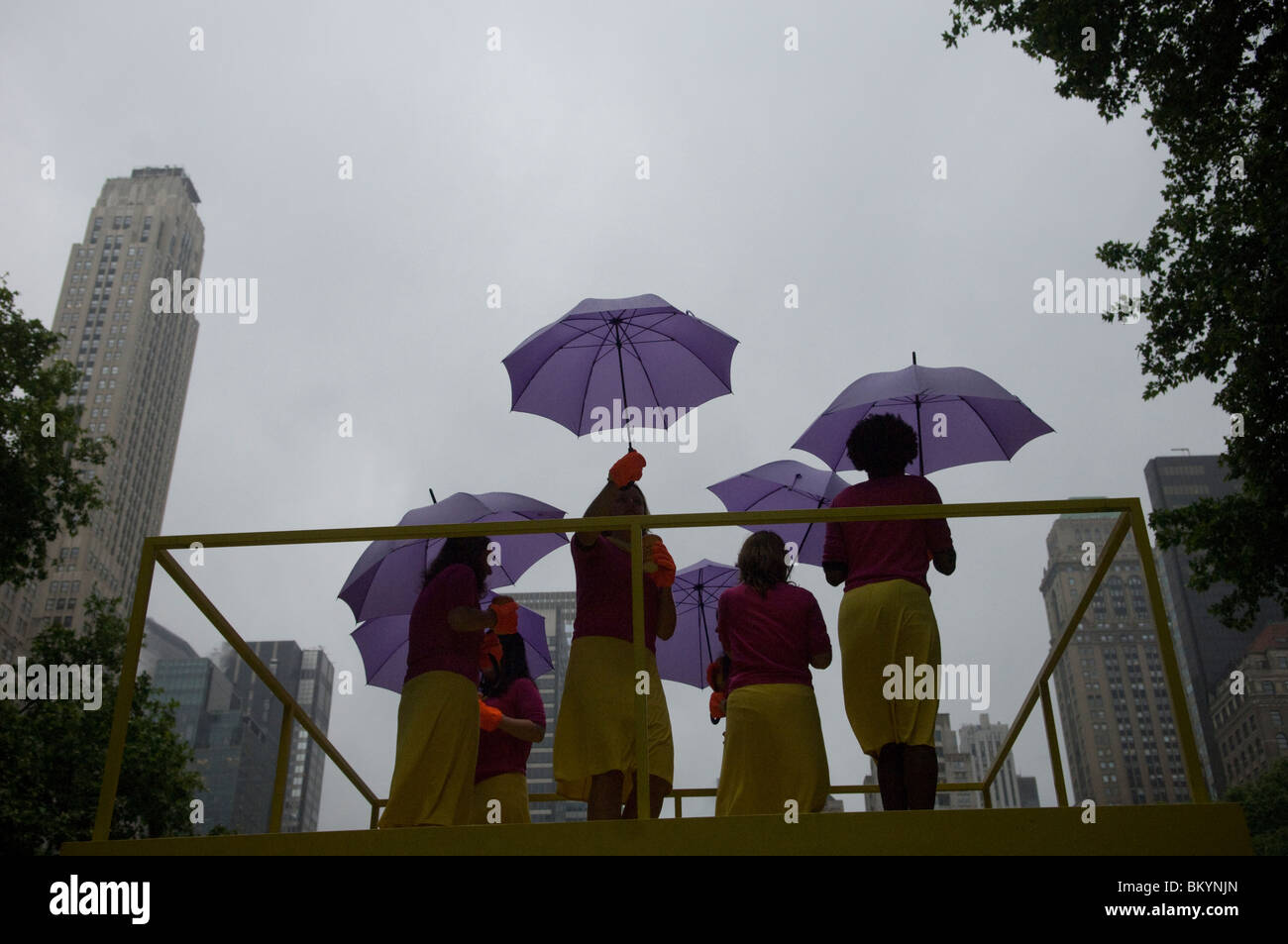 Le donne eseguire "Camminare", sotto la pioggia, un progetto d'arte dell'artista Kate Gilmore, in Bryant Park di New York Foto Stock