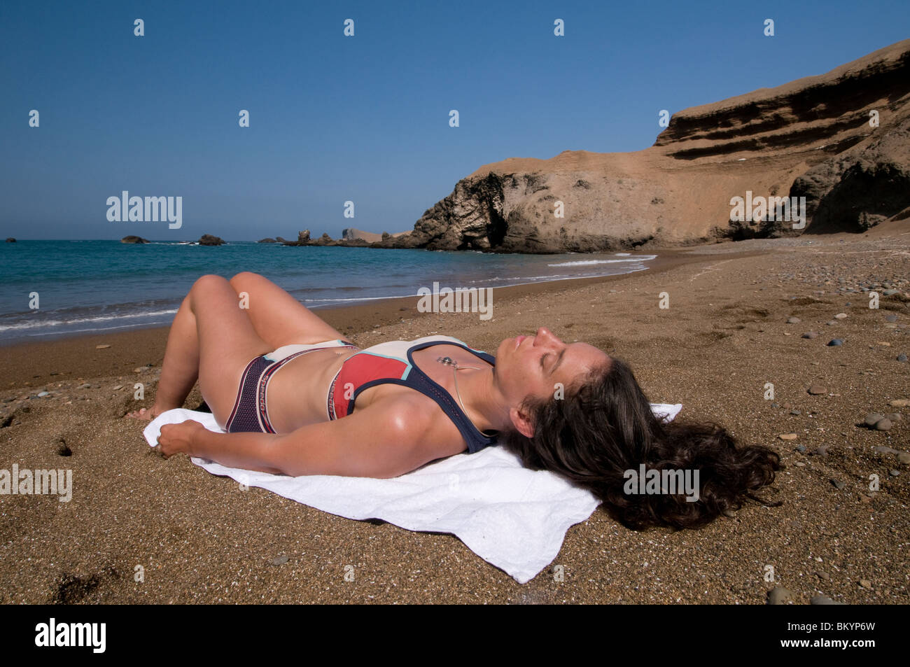 La donna a prendere il sole sulla spiaggia deserta in Perù Foto Stock