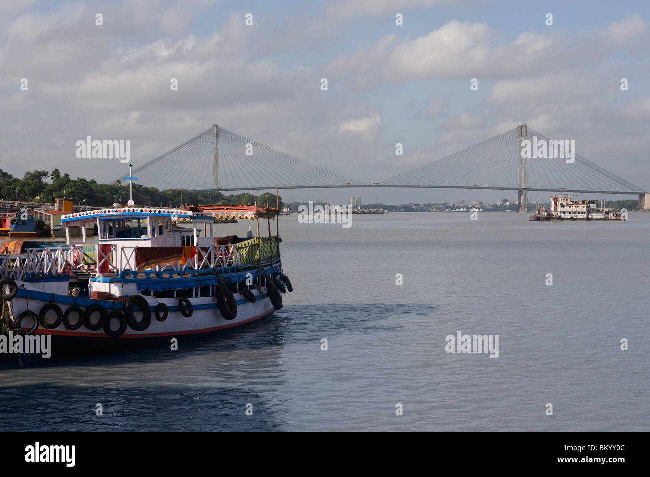 Barca con un ponte in background, Vidyasagar Setu, Fiume Hooghly, Calcutta, West Bengal, India Foto Stock