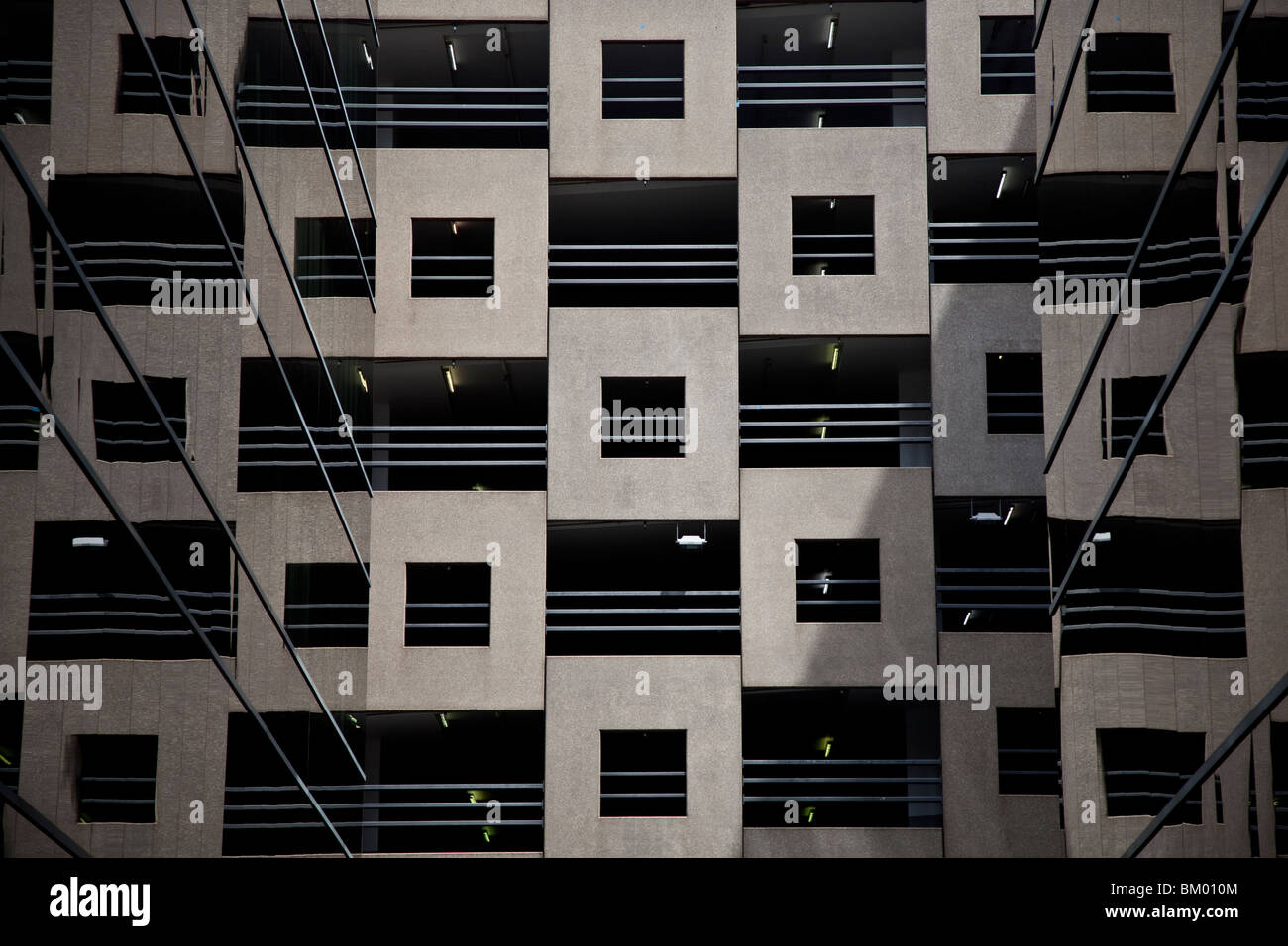 Motivo di quadrati nella progettazione della facciata del balcone con ringhiera in un edificio a più piani riflette in vetro su entrambi i lati. Foto Stock