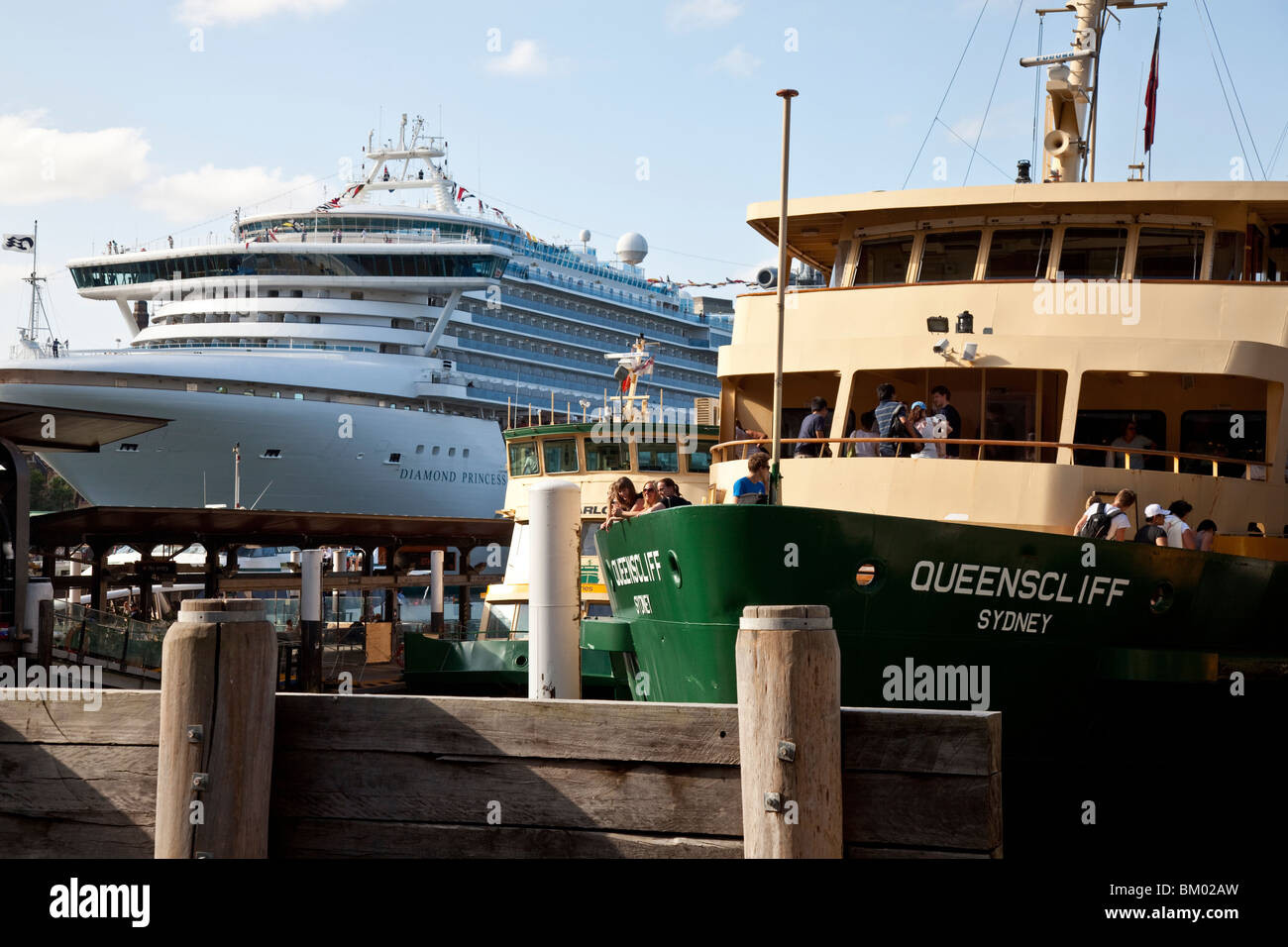 La gente sul traghetto Manly accanto a una nave da crociera in Circular Quay, Porto di Sydney Foto Stock