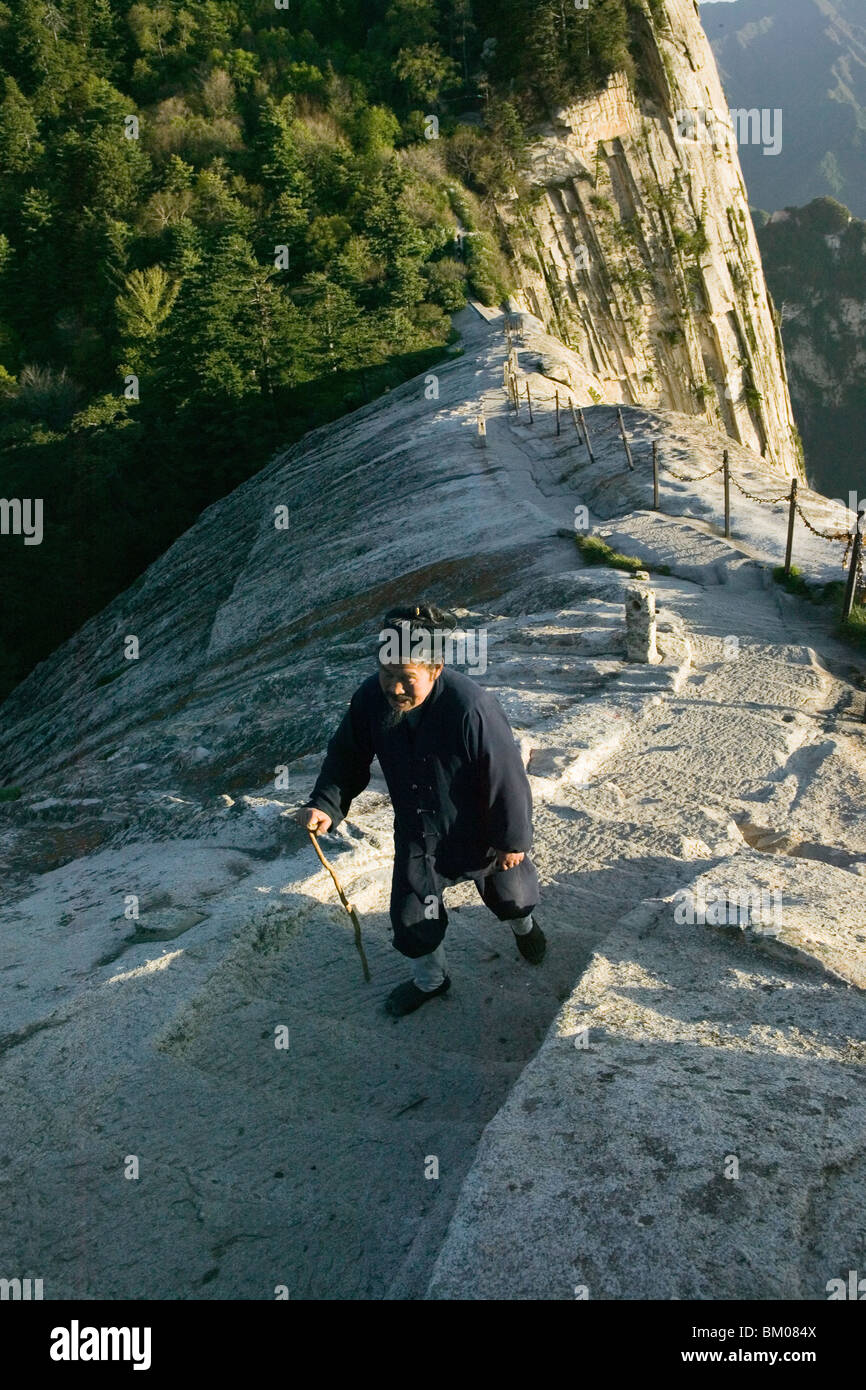 Monaco daoista sul pesce torna Ridge, avvicinando cui Yun Gong Monastero il picco del Sud, cammino di pellegrino lungo la scalinata in pietra con mano a catena Foto Stock