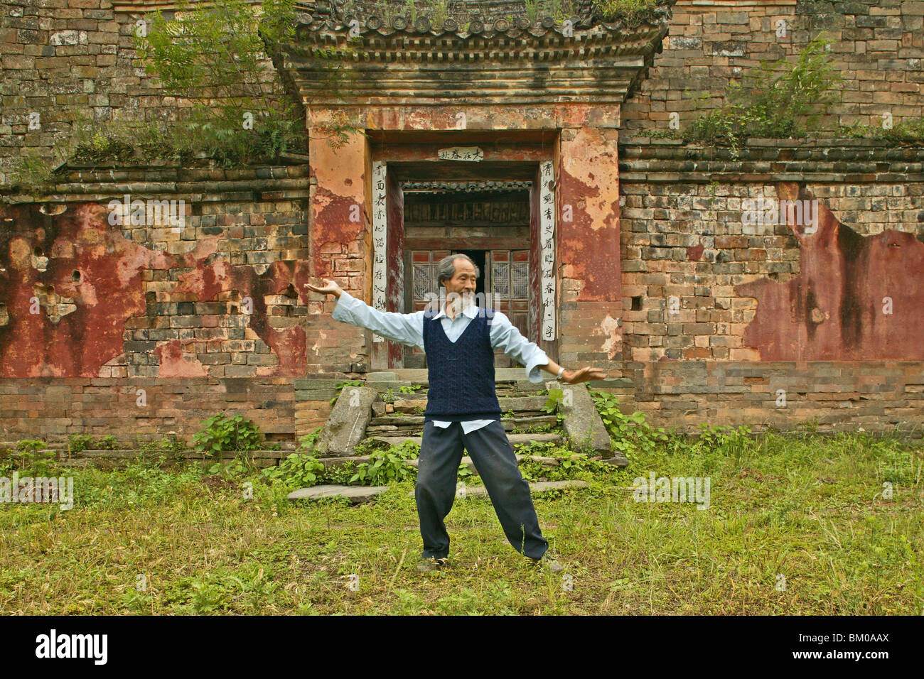 Master dimostra di Taichi movimenti, nella parte anteriore della sua vecchia casa al di sotto del picco, Wudang Shan, taoista di montagna, provincia di Hubei, Wu Foto Stock