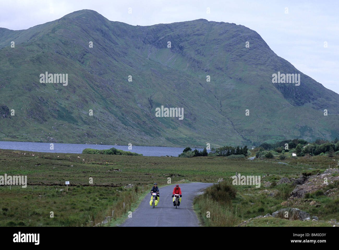 I ciclisti su strada Connemara, vicino al Lough a pagamento, nella contea di Galway, Irlanda Foto Stock