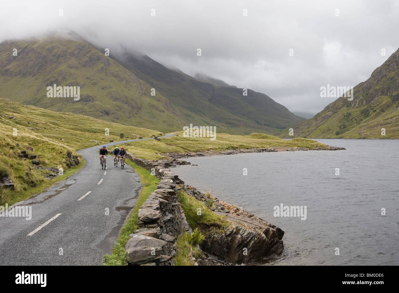 I ciclisti sfidando Vento e meteo, vicino a Delphi, County Mayo, Irlanda Foto Stock