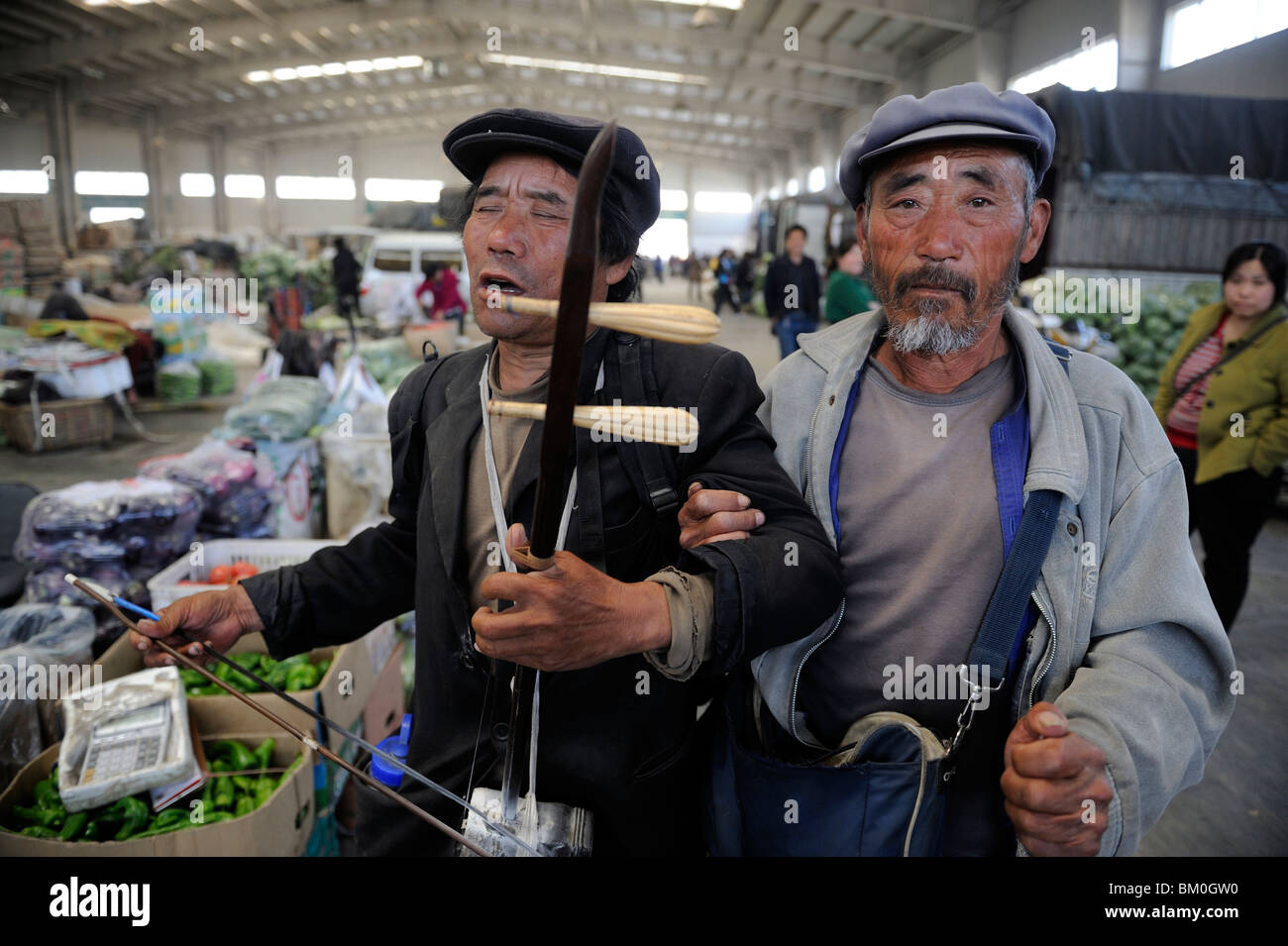 Due uomini cinesi da poveri Cina occidentale di eseguire per denaro presso un mercato all'ingrosso a Pechino in Cina. 12-Maggio-2010 Foto Stock