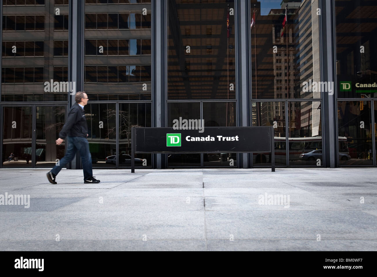 Un uomo cammina da un TD Canada Trust logo in Toronto financial district Foto Stock