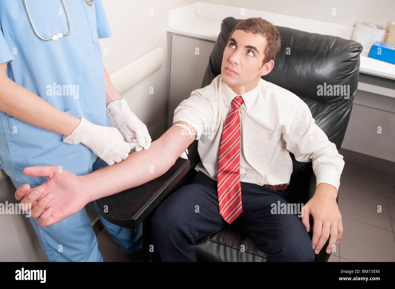 Medico tenendo campione di sangue di un uomo Foto Stock