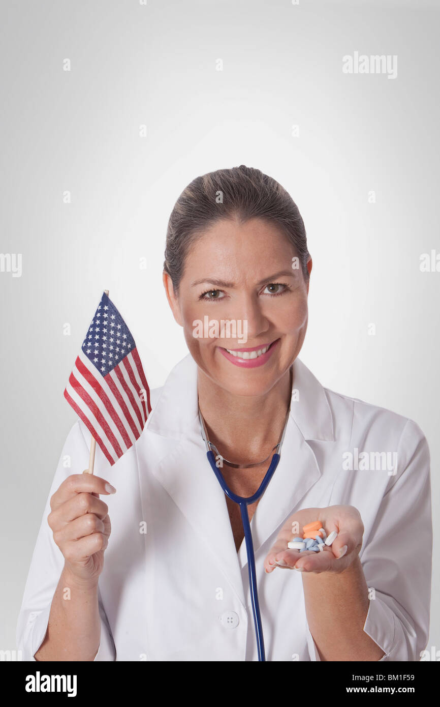 Medico donna tenendo una bandiera americana Foto Stock