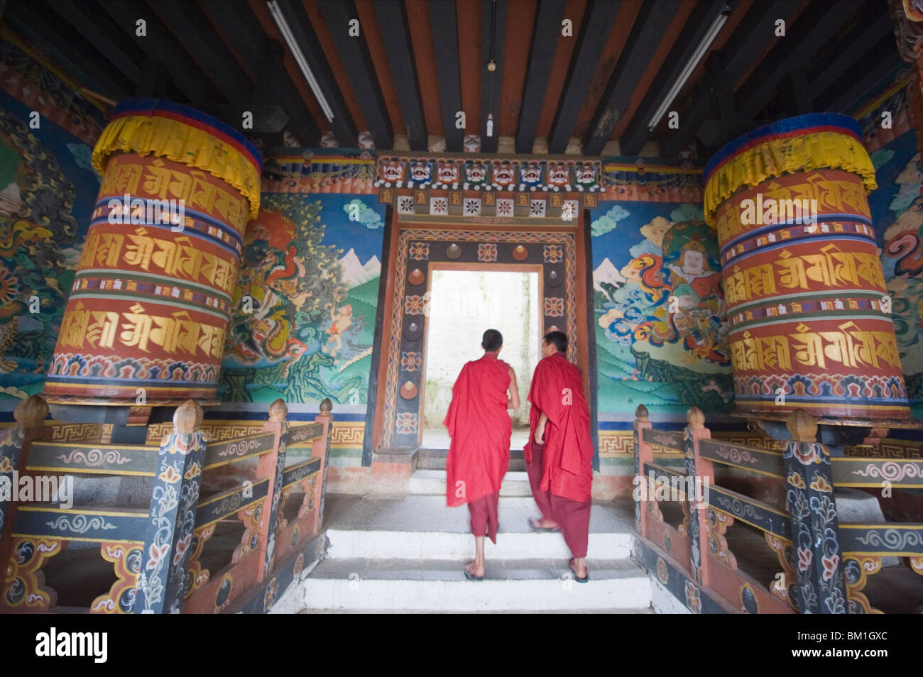 I monaci a passeggio tra ruote della preghiera a Trongsa Dzong (Chokhor Raptentse) risalente al 1648, Bhutan Asia Foto Stock