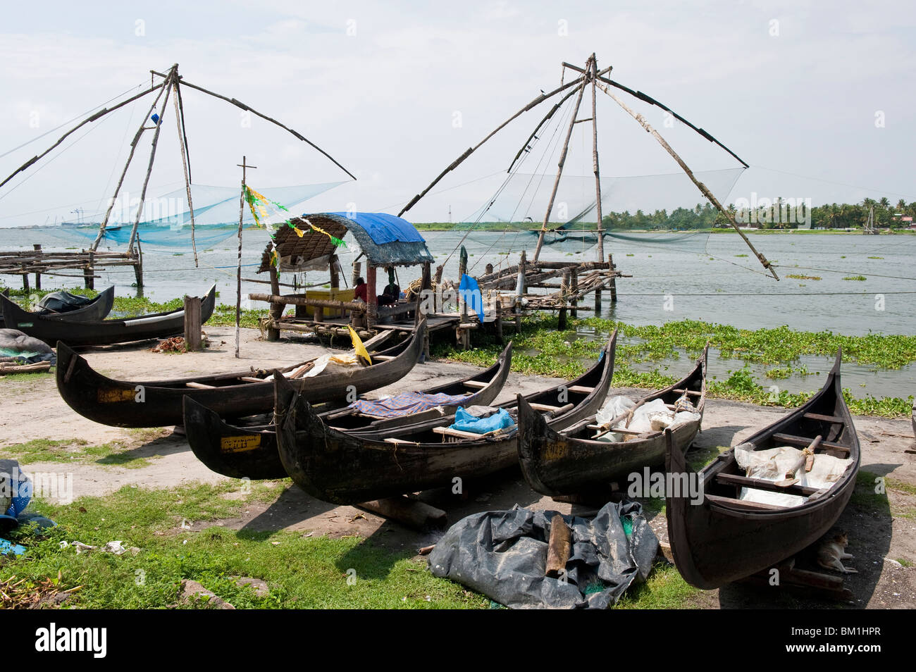 Spiaggiata canoe di pesca vicino al cinese di reti da pesca a Cochin, India Foto Stock