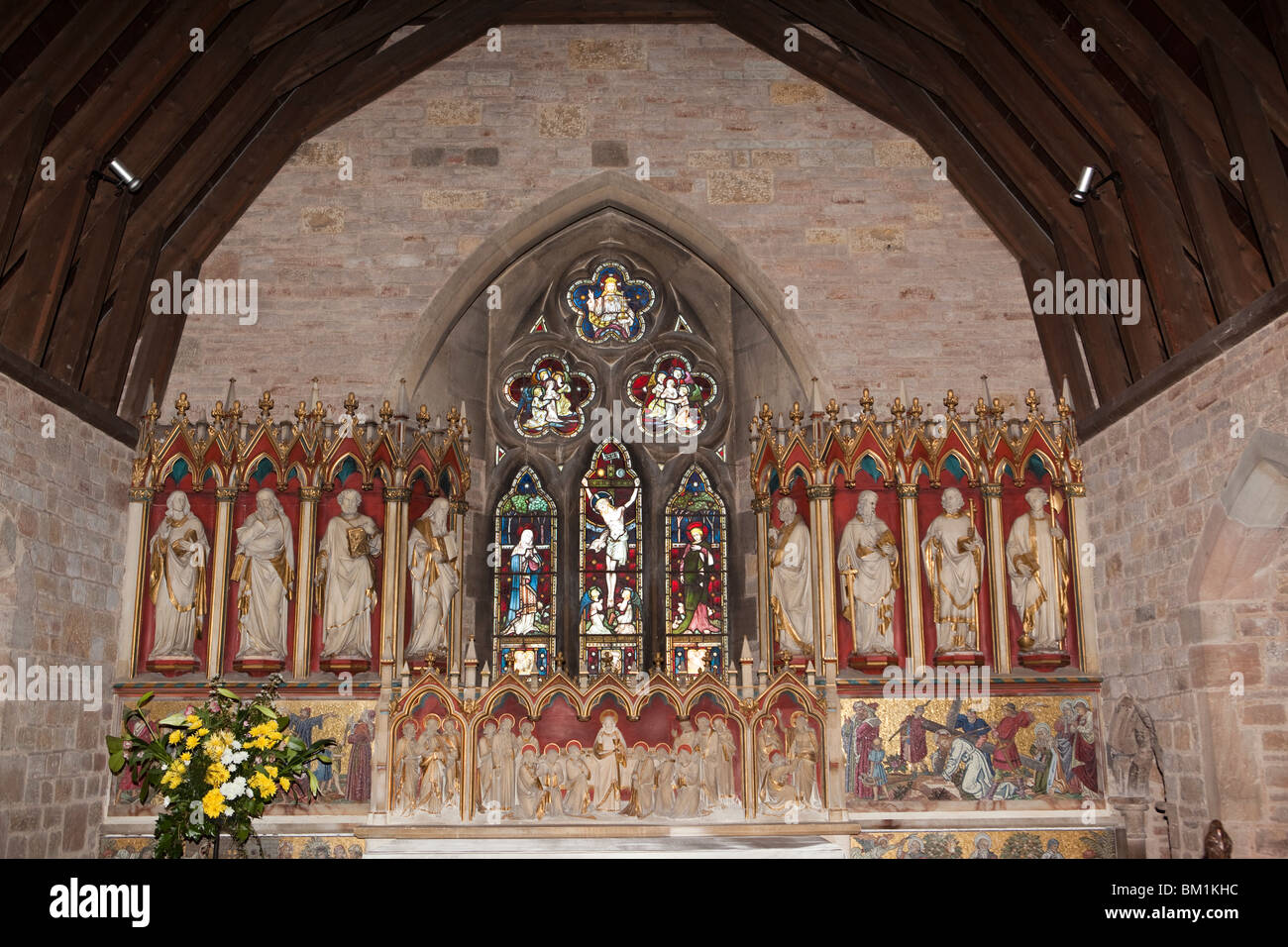 Regno Unito, Inghilterra, Herefordshire, Putley chiesa, in legno riccamente intagliato e dipinto reredos gotico in stile revival Foto Stock