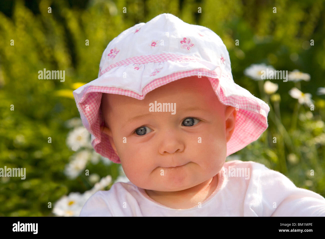 Bella 6 mese vecchia ragazza bambino neonato bimbo in rosa cappello hat nel  sole nel giardino esterno all'aperto gli occhi blu Foto stock - Alamy