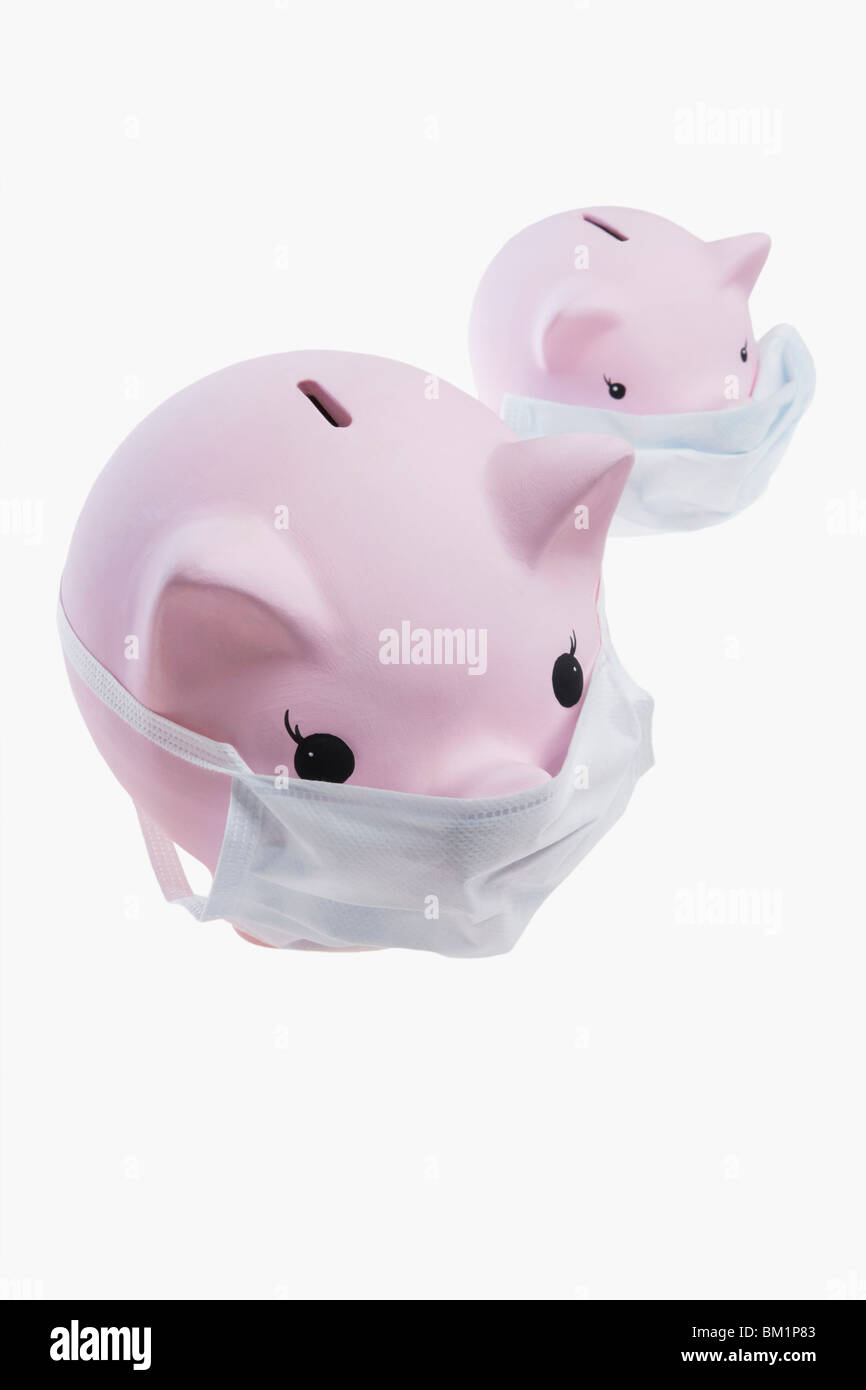 Close-up di piggy banche indossando maschere di influenza Foto Stock
