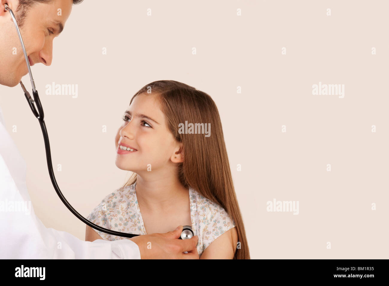 Medico di esaminare una ragazza con uno stetoscopio Foto Stock