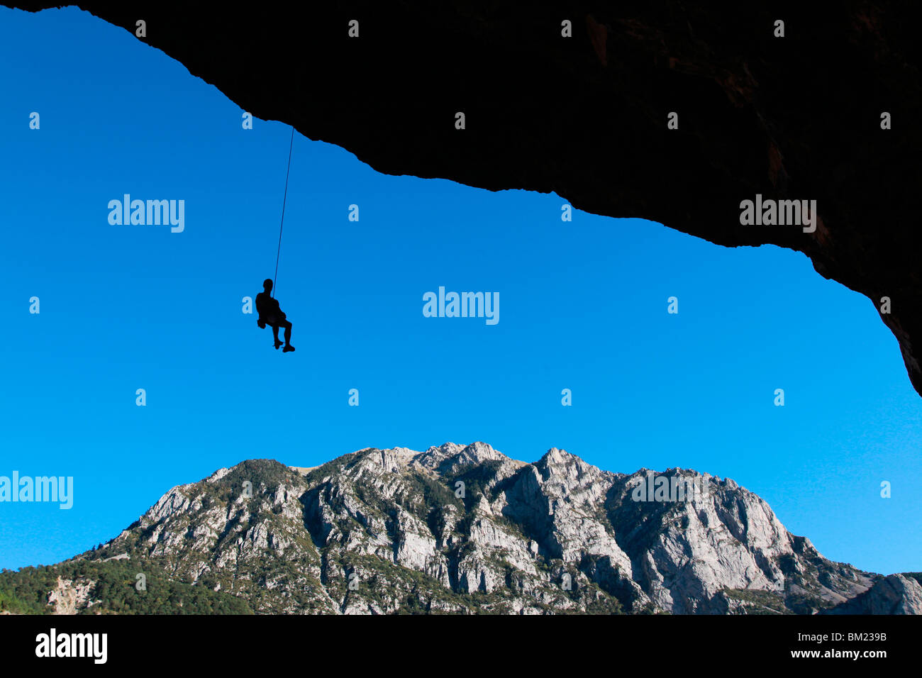 Un scalatore abbassa off molto sovrastante grotta salire sulle scogliere di Bielsa, Pirenei spagnoli, Aragona, Spagna Foto Stock