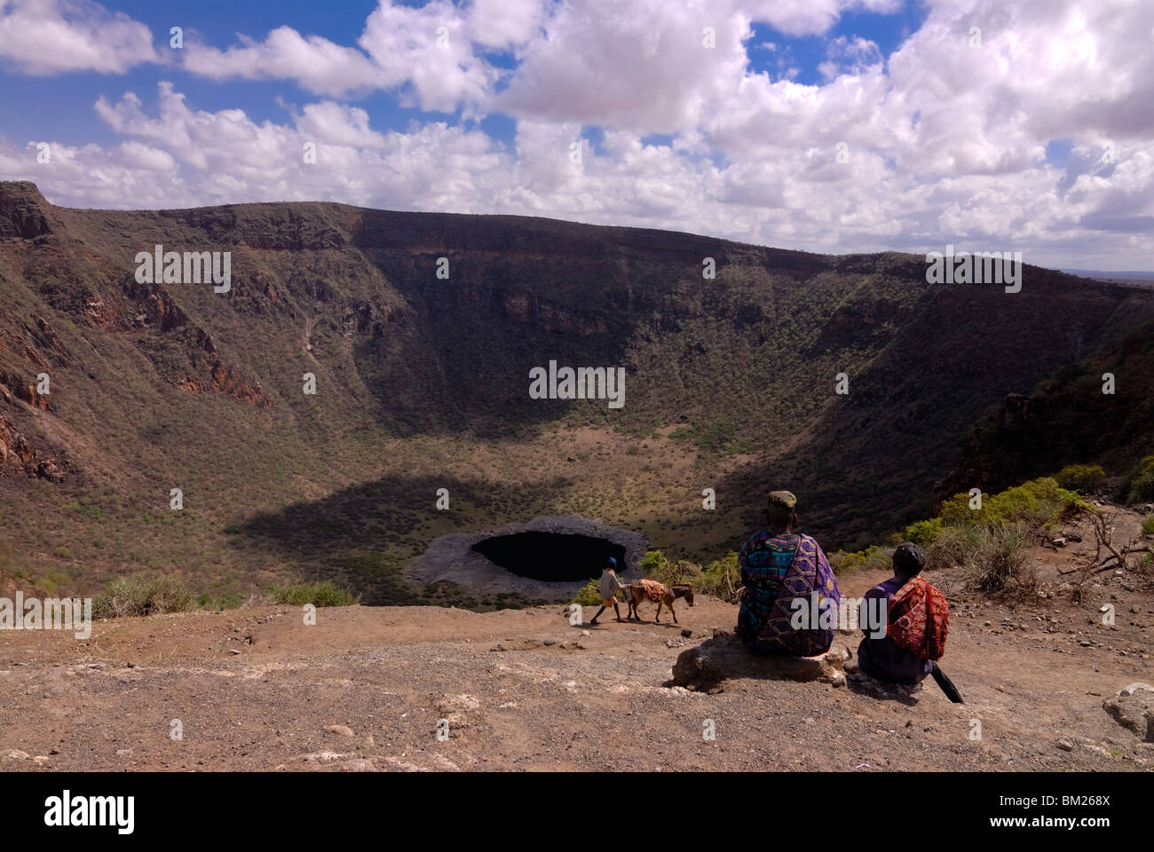 Il vecchio uomo e figlio in attesa di scendere nel cratere di soda a scavare per sale, vicino a Moyale, su un Etiope frontiera keniana, Etiopia Foto Stock