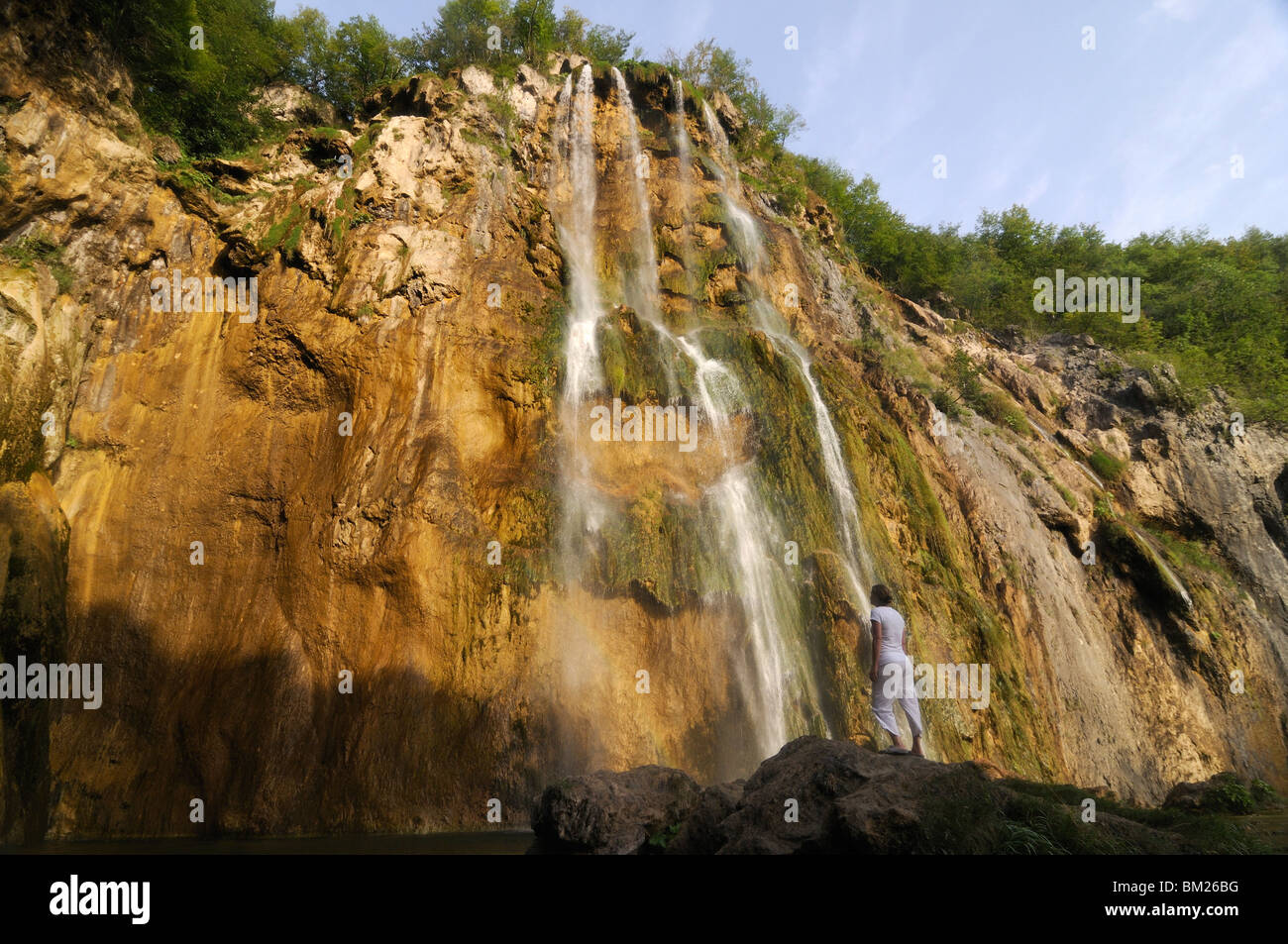 Donna ammirando il gigante cascata nel Parco Nazionale dei Laghi di Plitvice, patrimonio mondiale dell UNESCO, Croazia, Europa Foto Stock