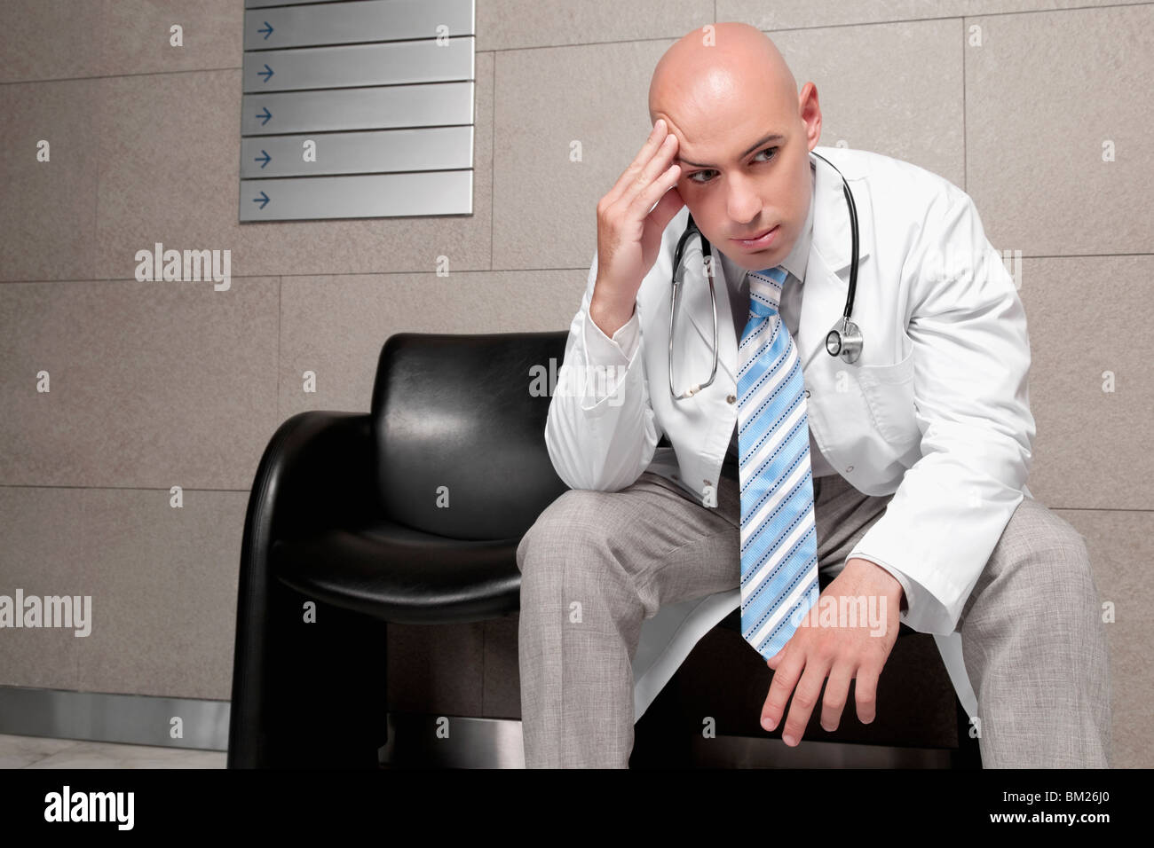 Medico seduto su una sedia e la ricerca ha sottolineato Foto Stock