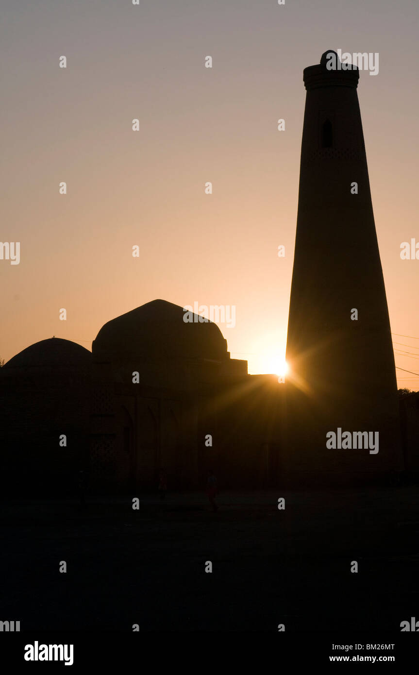 Silhouette di un minareto nel sole di setting, Khiva, Uzbekistan in Asia centrale Foto Stock