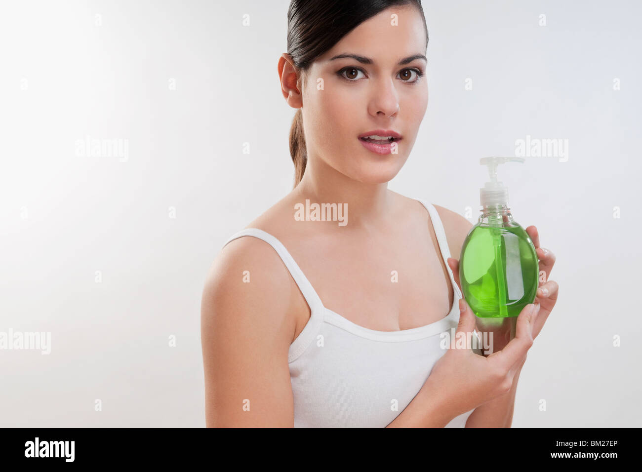 Ritratto di una donna in possesso di una bottiglia di sapone liquido Foto Stock