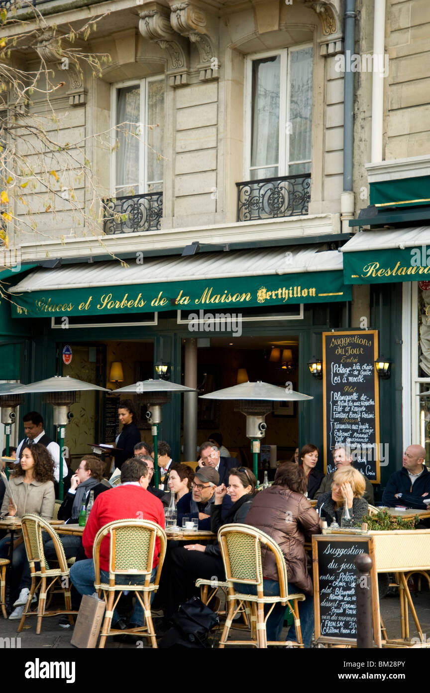 La gente seduta al di fuori di un cafè sulla Ile Saint Louis, Parigi, Francia Foto Stock