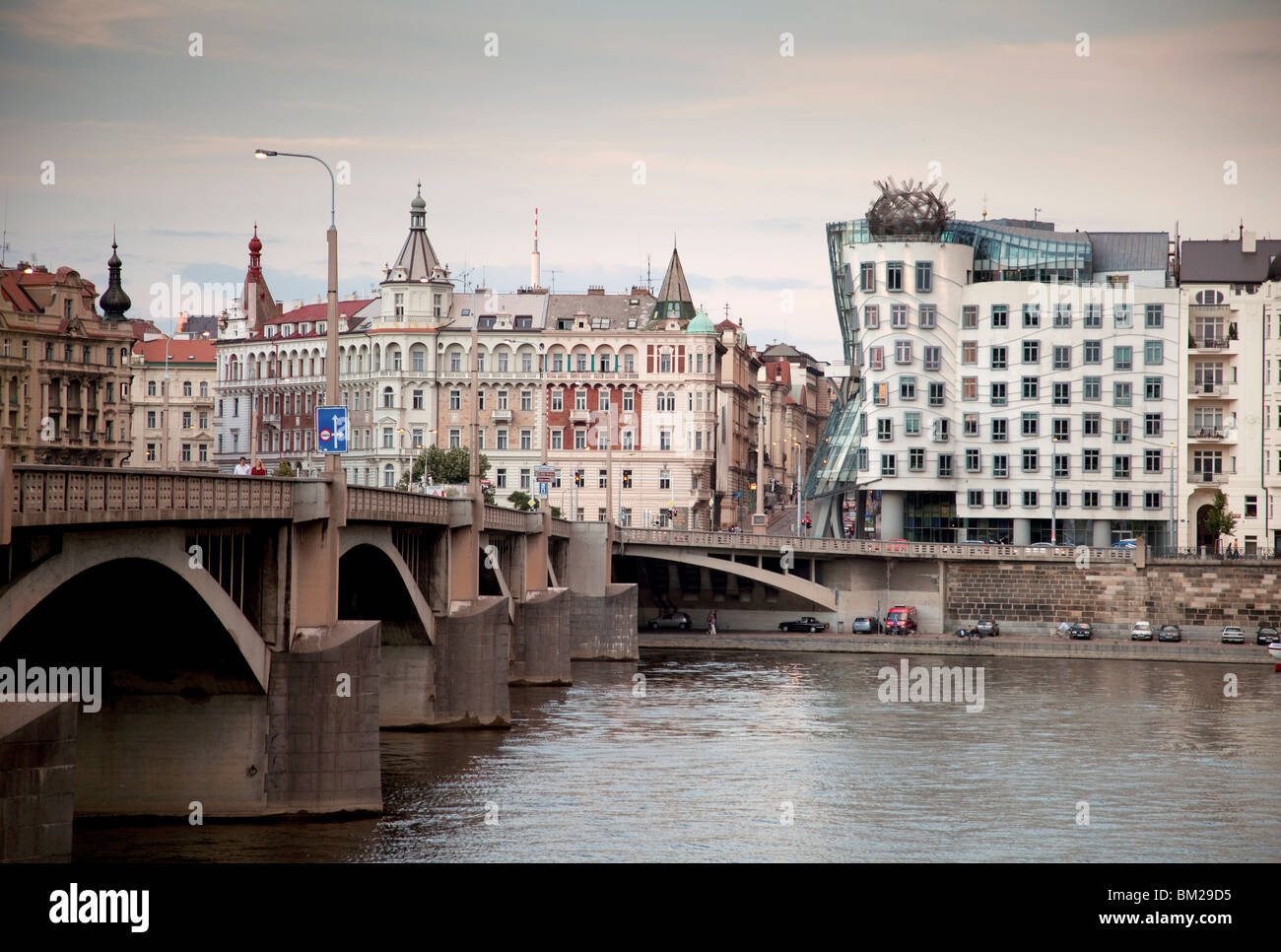 Sponda Est del Fiume Vltava con la Casa Danzante di Frank Gehry costruito nel 1996, e il Ponte Jiraskuv, Praga, Repubblica Ceca Foto Stock