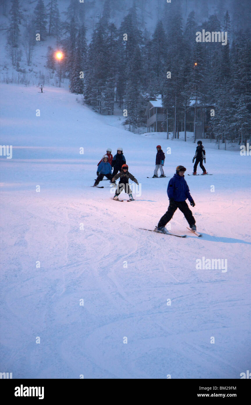 I bambini che frequentano la scuola di sci al tramonto, Pyha-Luosto ski resort, Lapponia, Finlandia e Scandinavia Foto Stock