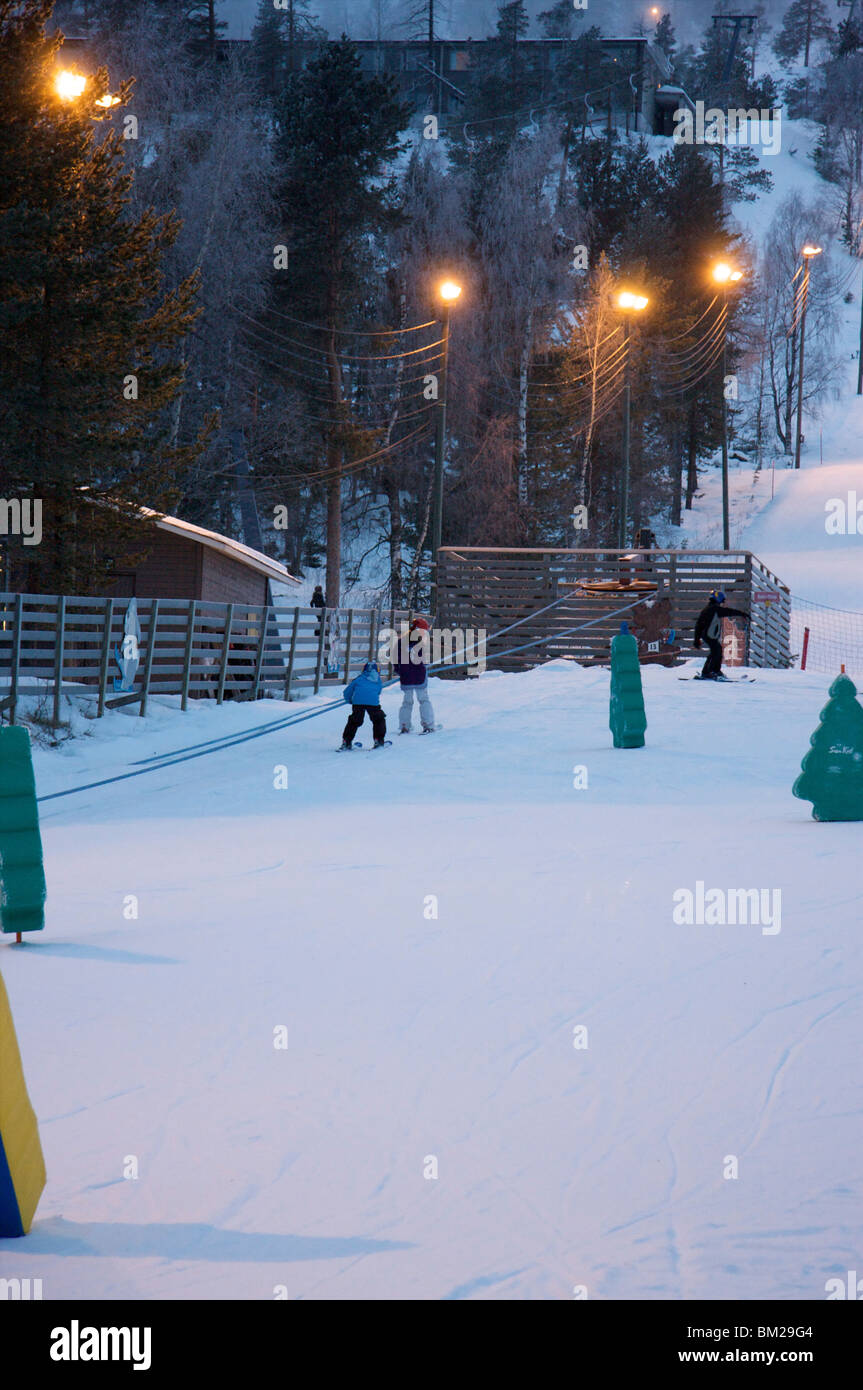 I bambini che frequentano la scuola di sci al tramonto, Pyha-Luosto ski resort, Lapponia, Finlandia e Scandinavia Foto Stock