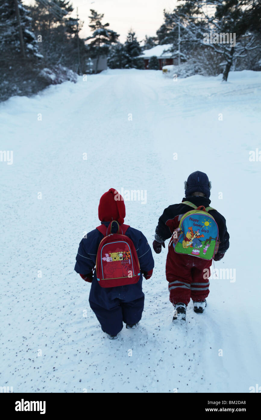 I FRATELLI NORDICI CAMMINANO FINO ALL'ASILO NIDO SULLA NEVE: I bambini piccoli camminano, camminano, camminano, neve, parco giochi, asilo nido, scuola materna Foto Stock