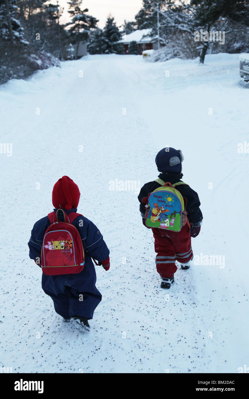 I FRATELLI NORDICI CAMMINANO FINO ALL'ASILO NIDO SULLA NEVE: I bambini piccoli camminano, camminano, camminano, neve, parco giochi, asilo nido, scuola materna Foto Stock