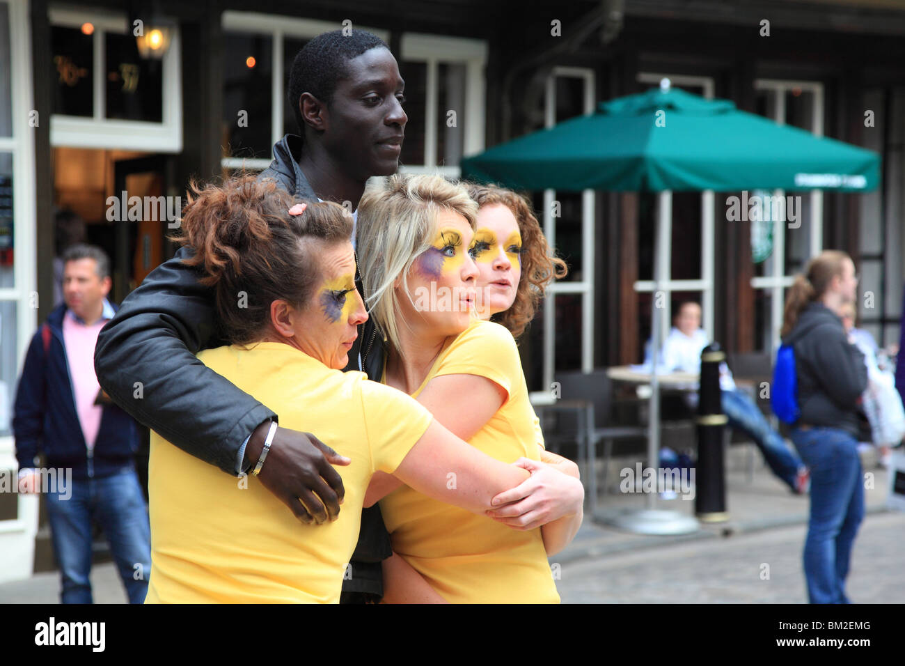 Tre donne con le facce dipinte che posano per una foto con un uomo Canterbury Kent England Foto Stock