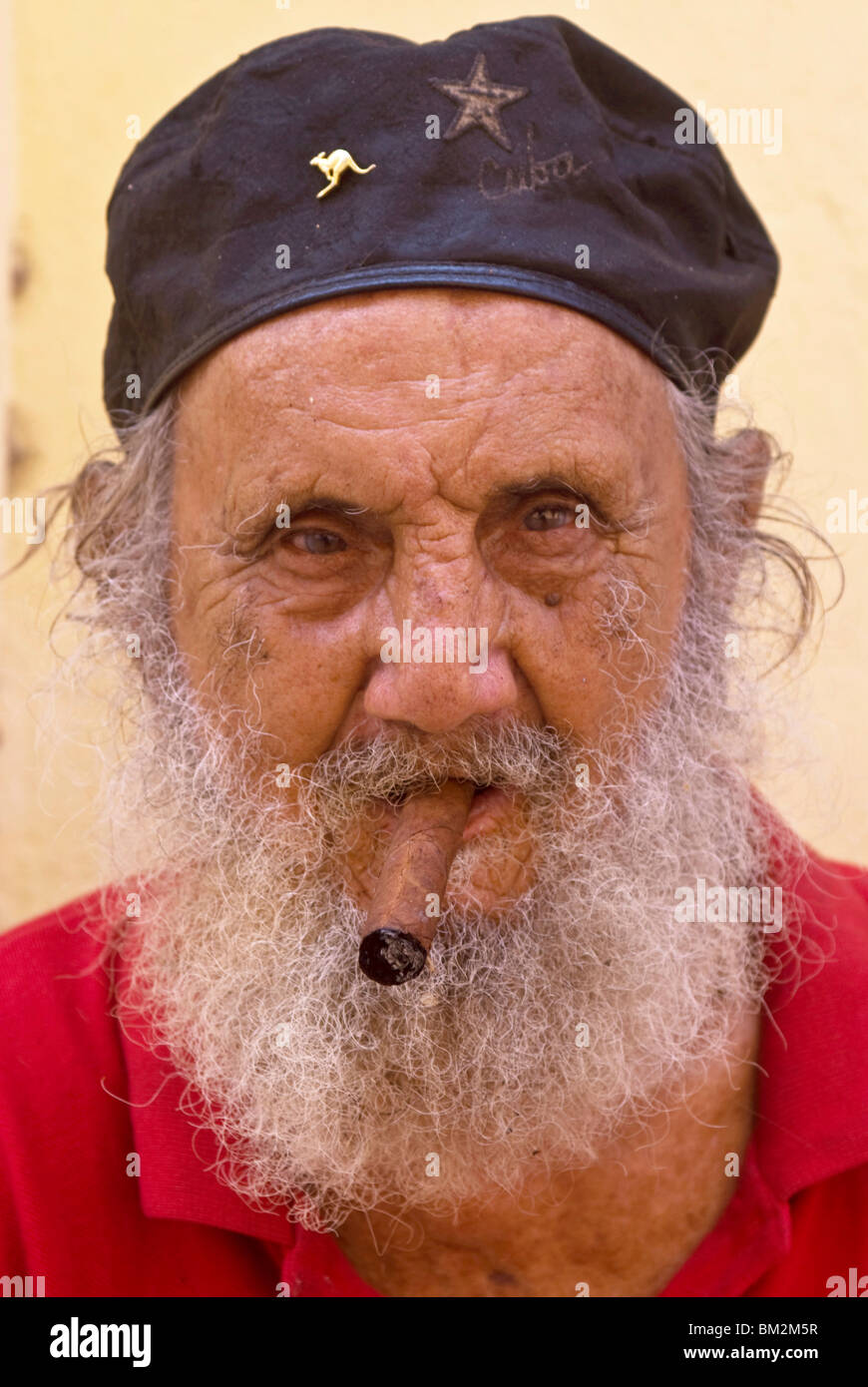Un vecchio uomo con cappuccio e barba bianca di fumare un sigaro Avana, Cuba, West Indies Foto Stock