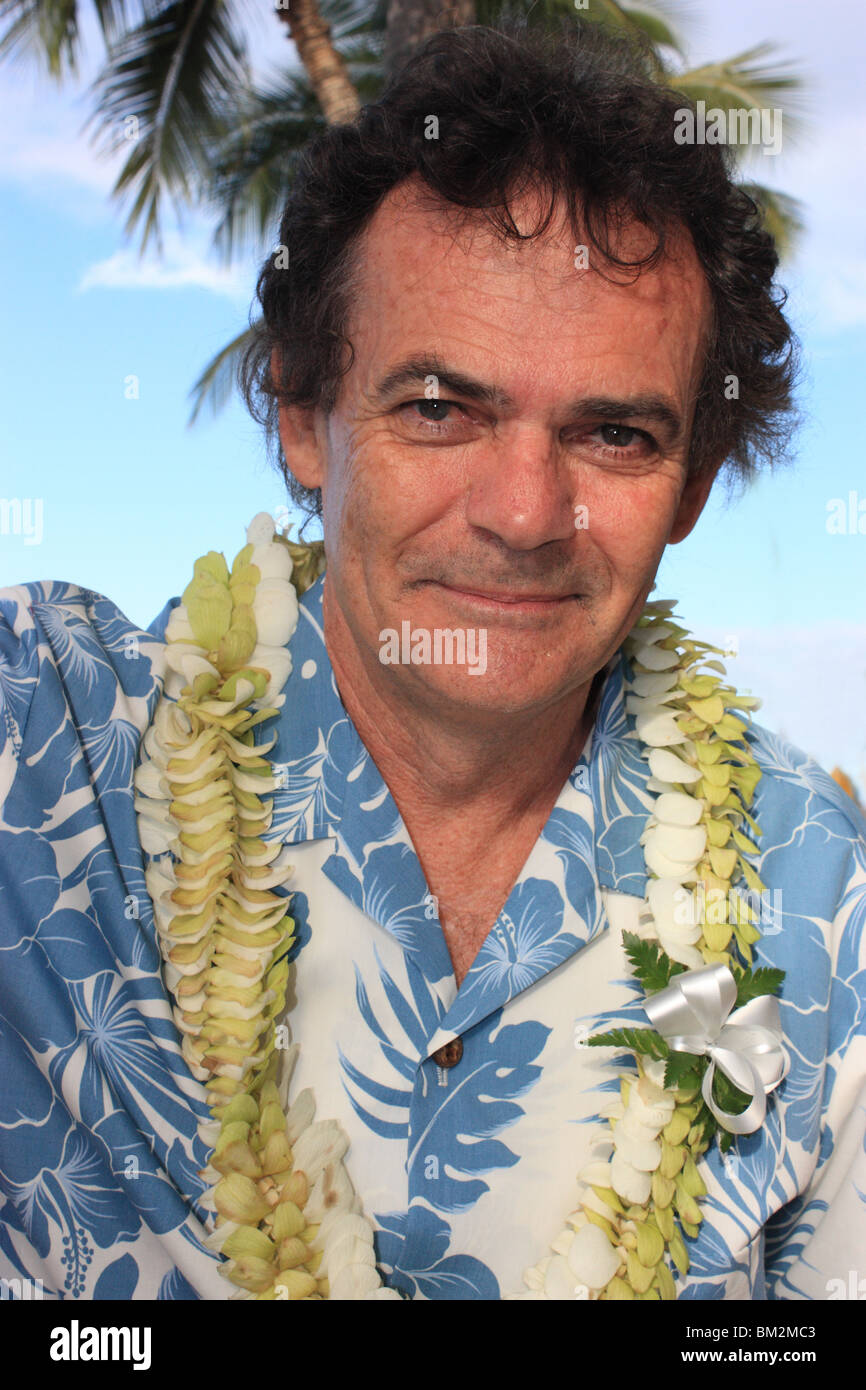 CLOSE up ritratto di cinquantacinque anni di Vecchio Uomo in camicia hawaiana E LEI sulla spiaggia di Waikiki Hawaii BDA Foto Stock