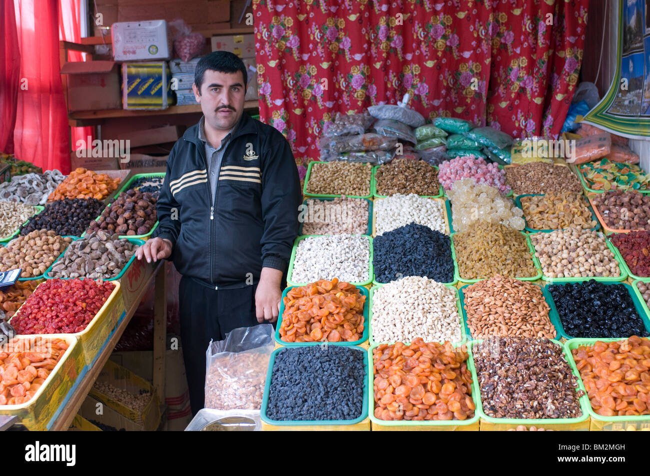 Shopseller nel bazar vendita di frutta secca, Almaty, Kazakhstan Foto Stock