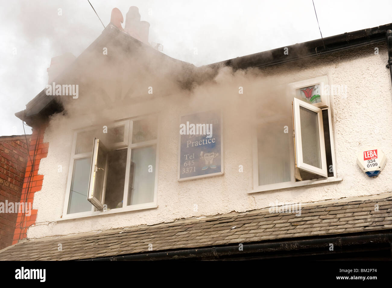 Il fumo versando da Windows di dentisti sul fuoco Foto Stock