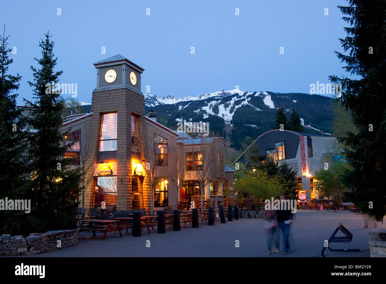 Il villaggio di Whistler al tramonto con il Brew pub ristorante e torre dell orologio con Blackcomb mountain in background Foto Stock