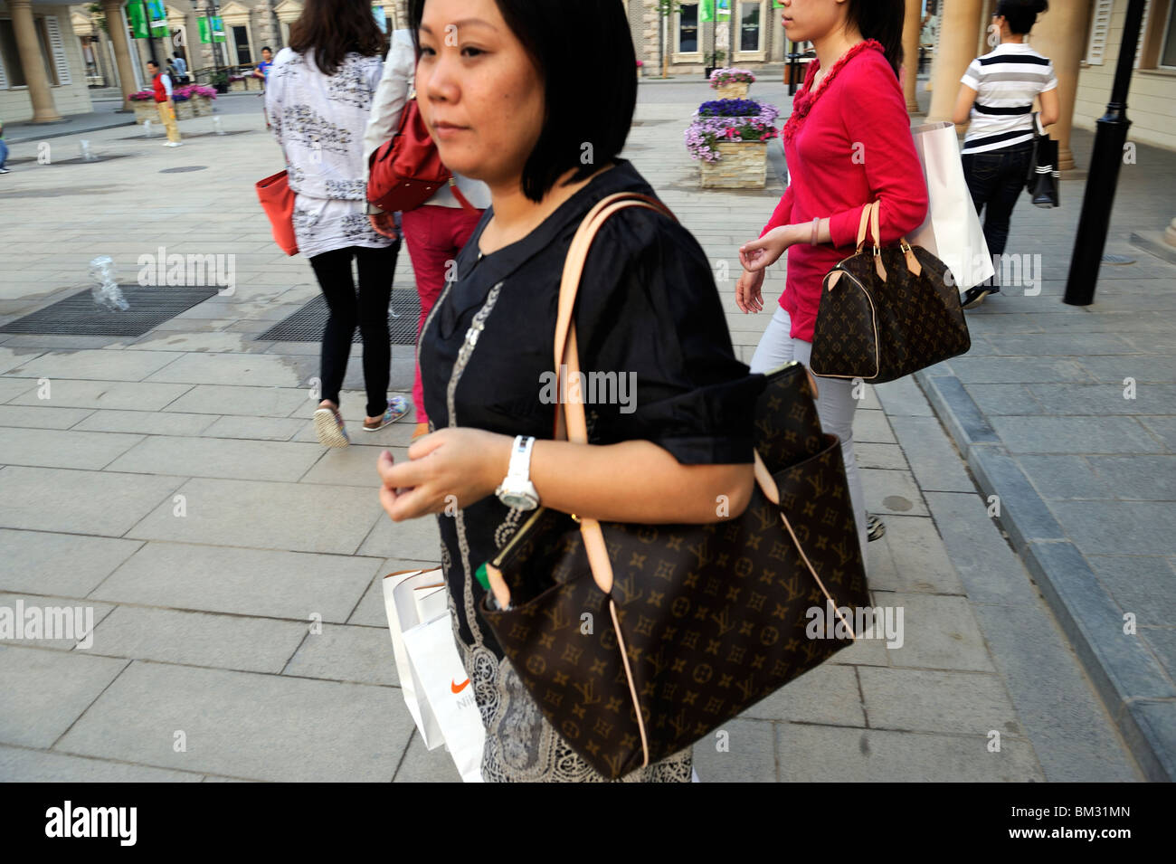 Due donne cinesi portano Louis Vuitton borse a Pechino Scitech Premium  Outlet Mall a Pechino in Cina. 15-Maggio-2010 Foto stock - Alamy