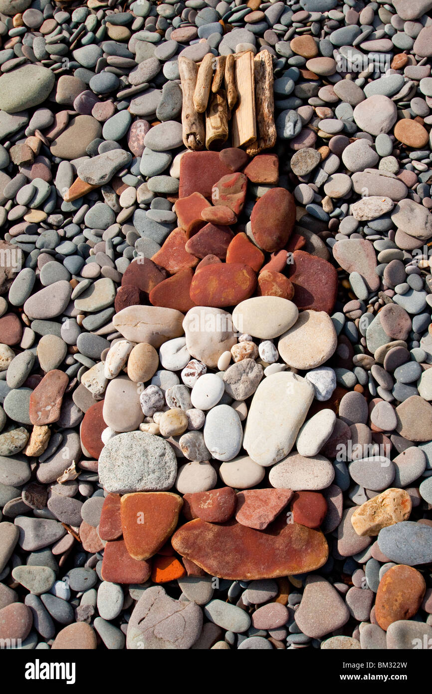 Ciottoli disposti su una spiaggia per simulare una bottiglia con tappo di sughero Foto Stock