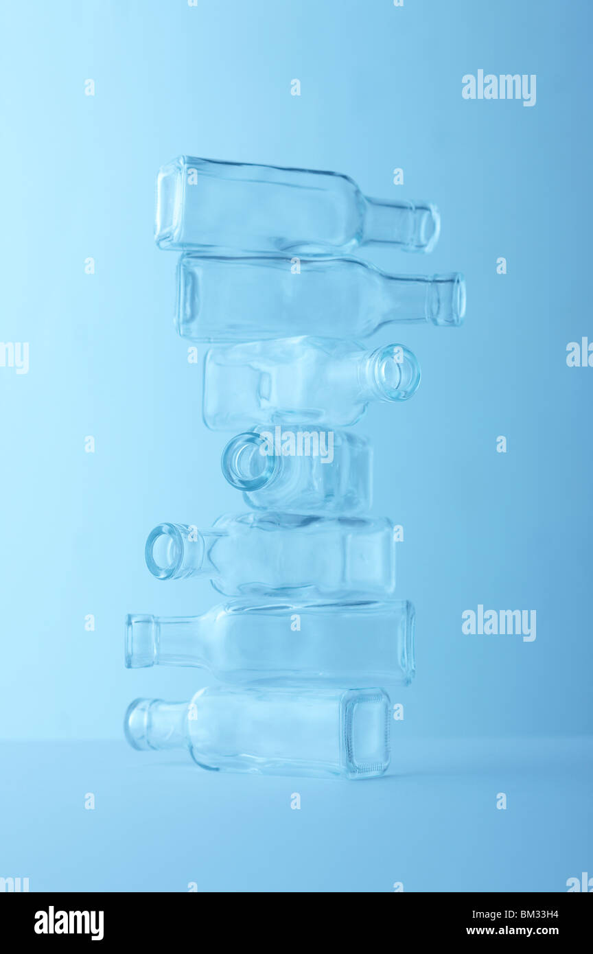 Torre di svuotare le bottiglie di vetro, sfondo blu, soft focus Foto Stock