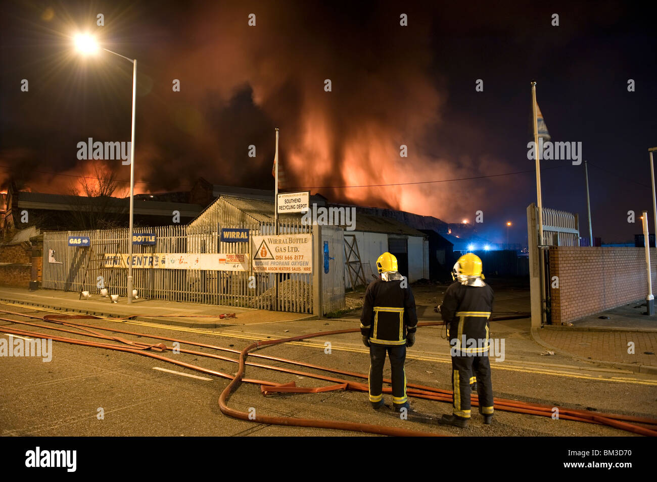 Grande magazzino di fabbrica sul fuoco di notte con un sacco di fiamme e fumo Foto Stock