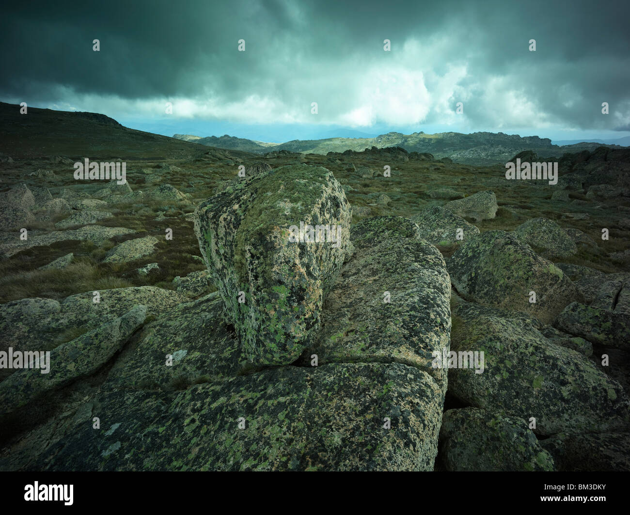 Erratics di granito e una vista delle condizioni tempestose sulla testa cilindri gamma, Kosciuszko National Park, NSW Australia Foto Stock
